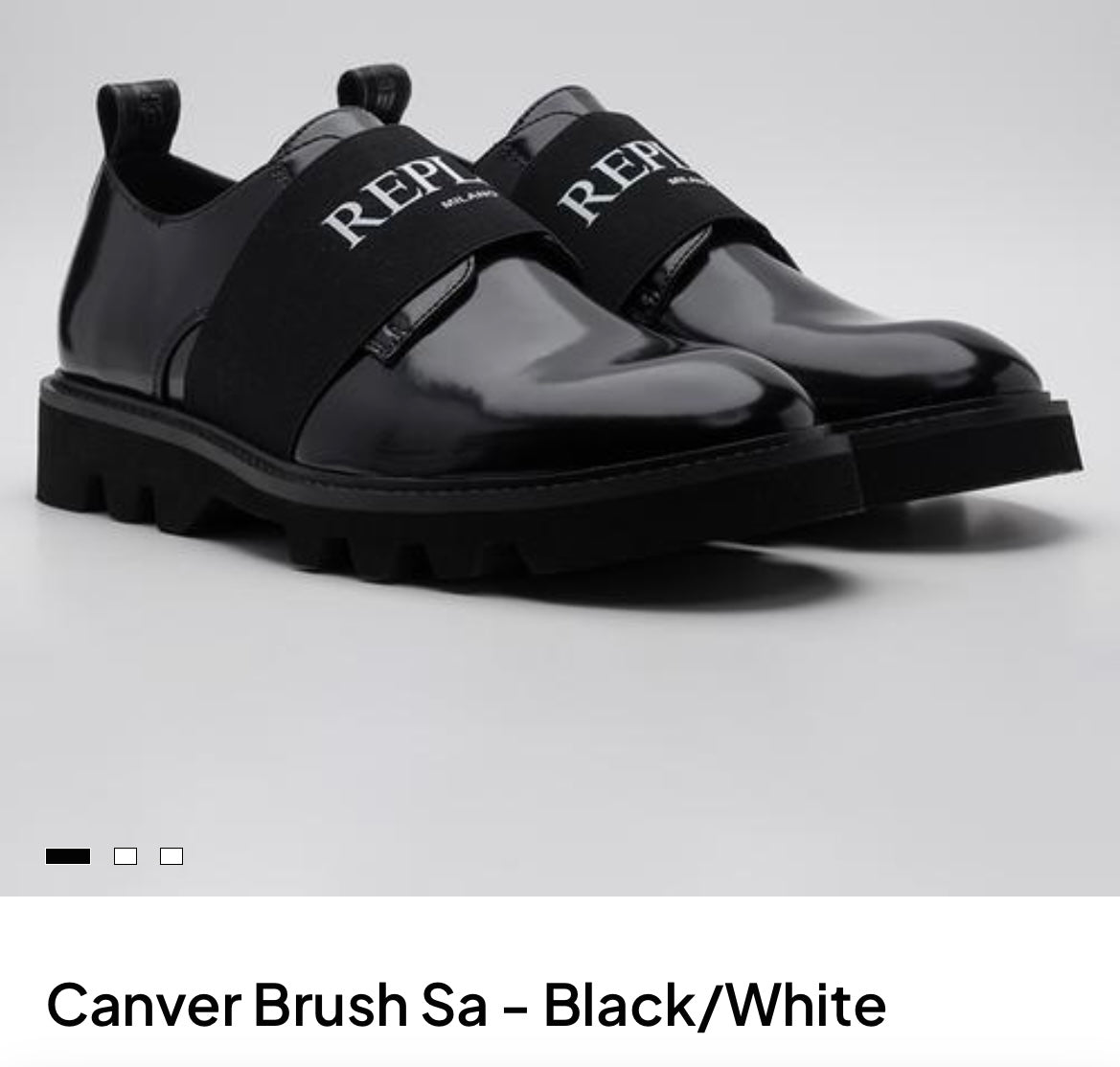 A pair of black patent leather slip-on shoes with wide black elastic straps featuring the white 'REPLAY' logo, set against a light gray background.