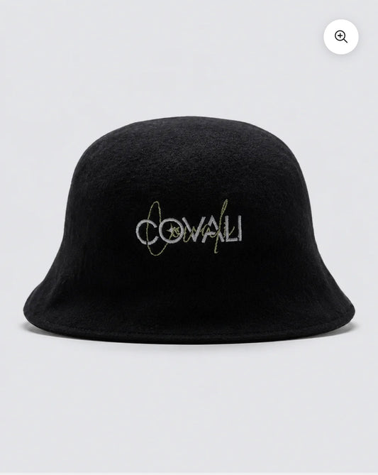 A black felt bucket hat with 'COVALI' embroidered on the front in white and gold, set against a light gray background.