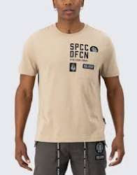 A man wearing a beige SPCC short-sleeve t-shirt with black graphic text and patches on the front, paired with dark gray drawstring pants, against a light gray background.